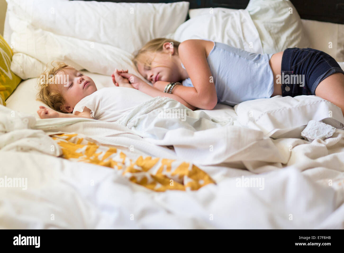 Ragazza caucasica e bimbo piccolo fratello addormentato sul letto Foto Stock