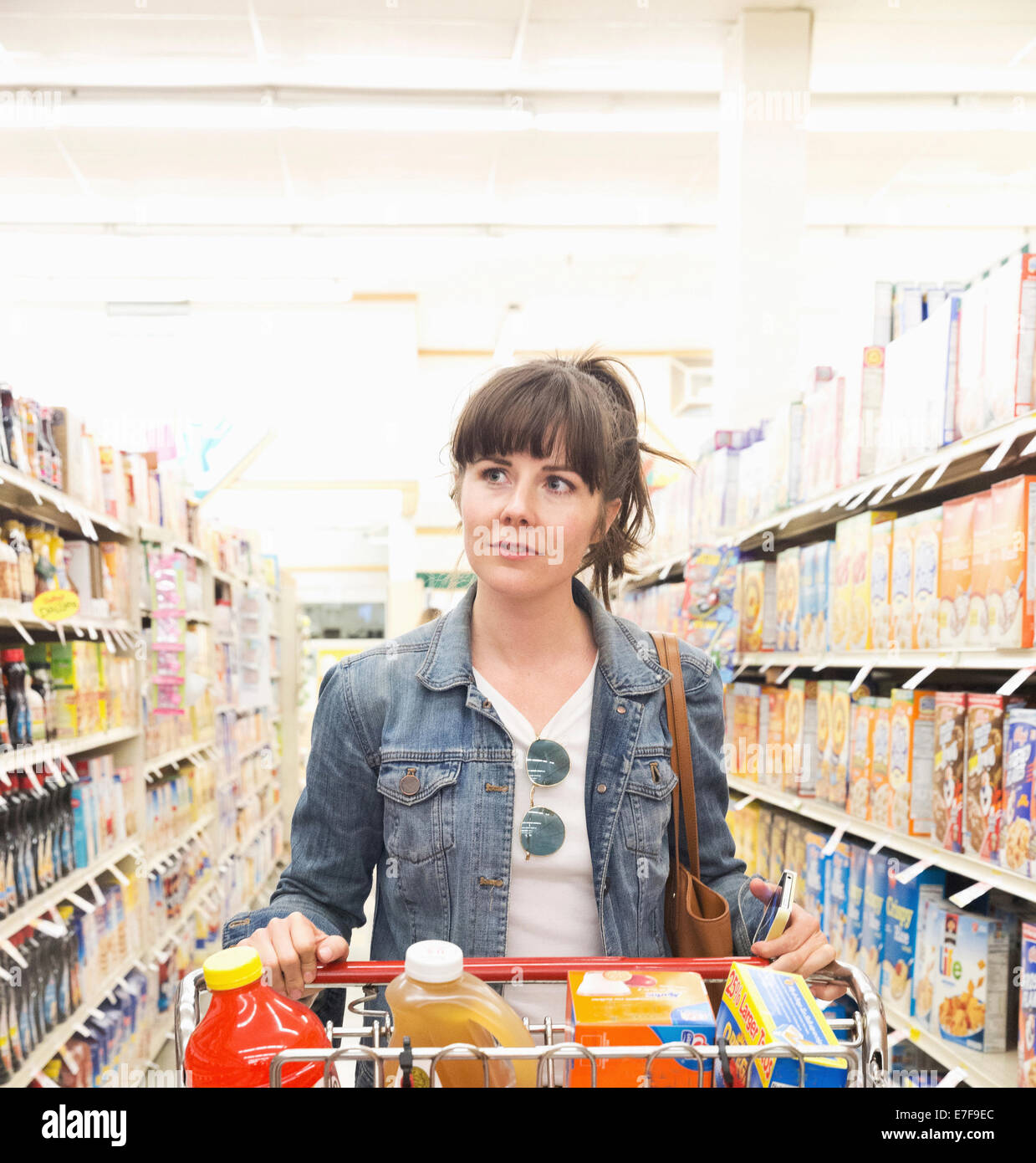 La donna caucasica carrello per la spesa in negozio Foto Stock