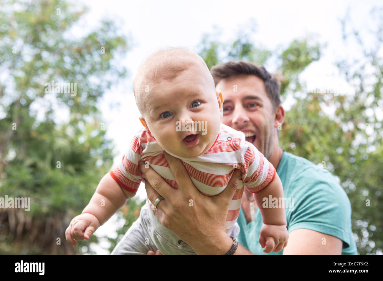 Padre caucasica giocando con il bambino all'aperto Foto Stock