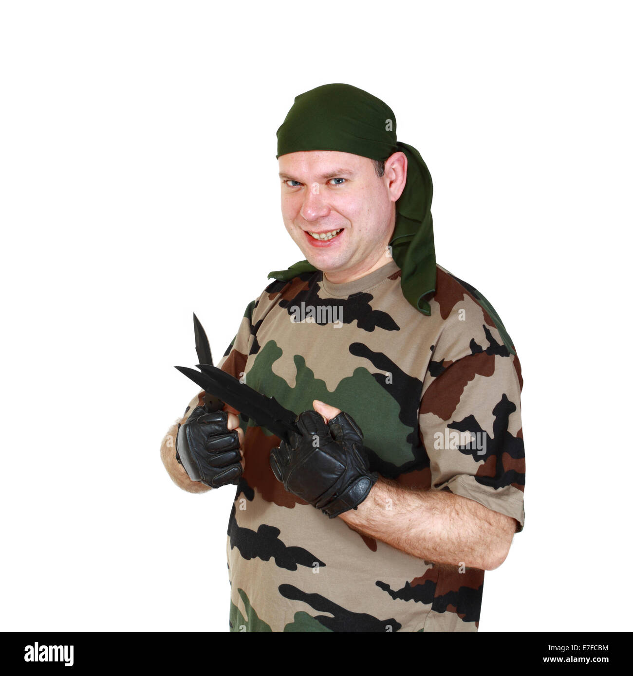Uomo in camuffamento a lanciare coltelli nelle mani e la collera di fronte. Isolato su sfondo bianco Foto Stock