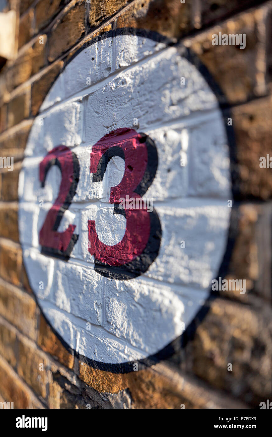 Numero 23 dipinta su un muro di mattoni a Londra Foto Stock