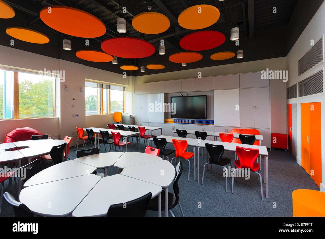 Non occupato in aula della scuola con colorato soffitto acustico dischi. Foto Stock