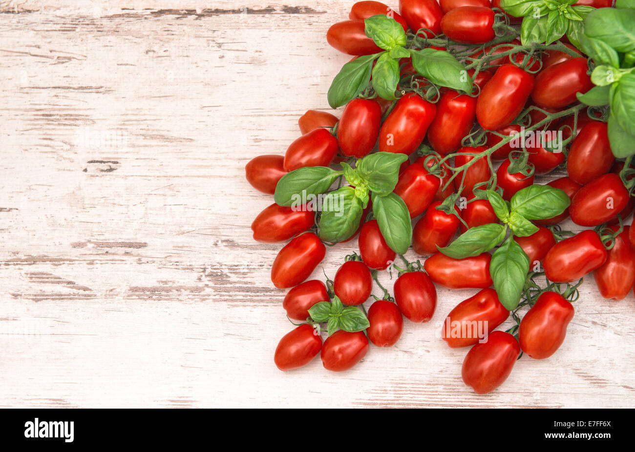 Pomodori ciliegini e le foglie di basilico. cibo sfondo. cucina italiana Foto Stock