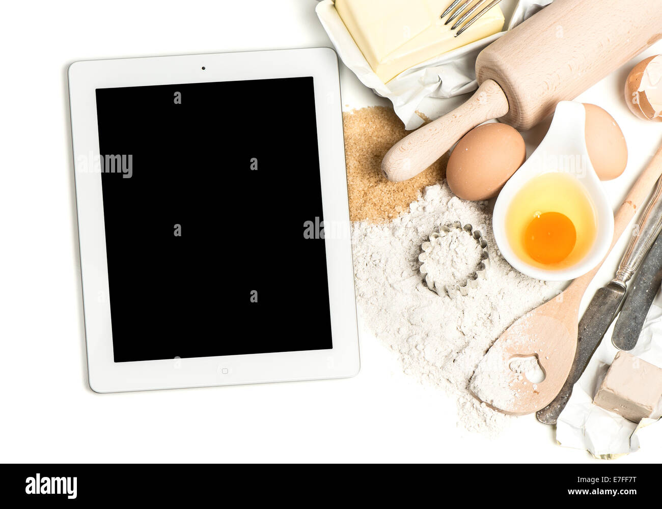 Notebook PC tablet e cottura ingredienti uova, farina, zucchero, burro, lievito. cibo sfondo con spazio per la tua ricetta digitale Foto Stock