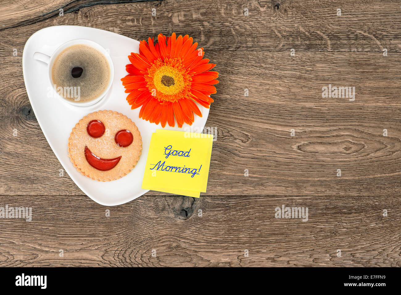 Il caffè con il cookie sorridente e daisy fiore. divertente prima colazione. Campione testo Buongiorno! Foto Stock