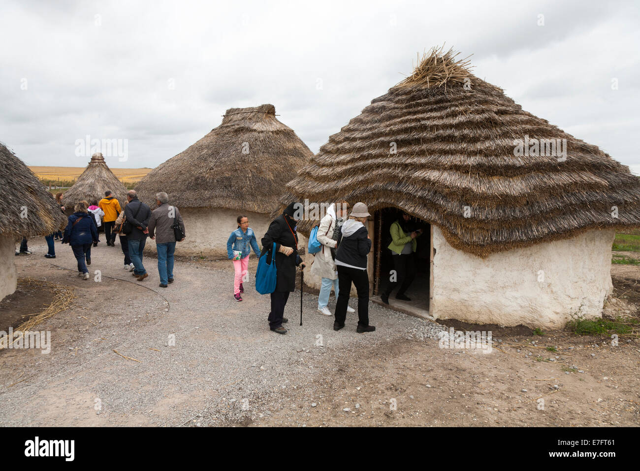 Visitatori turistici visualizza ricreato il neolitico Età della pietra hut / stoneage Baite & tetto di paglia / tetti Exhibition Visitor Center Stonehenge Stone Henge REGNO UNITO Foto Stock