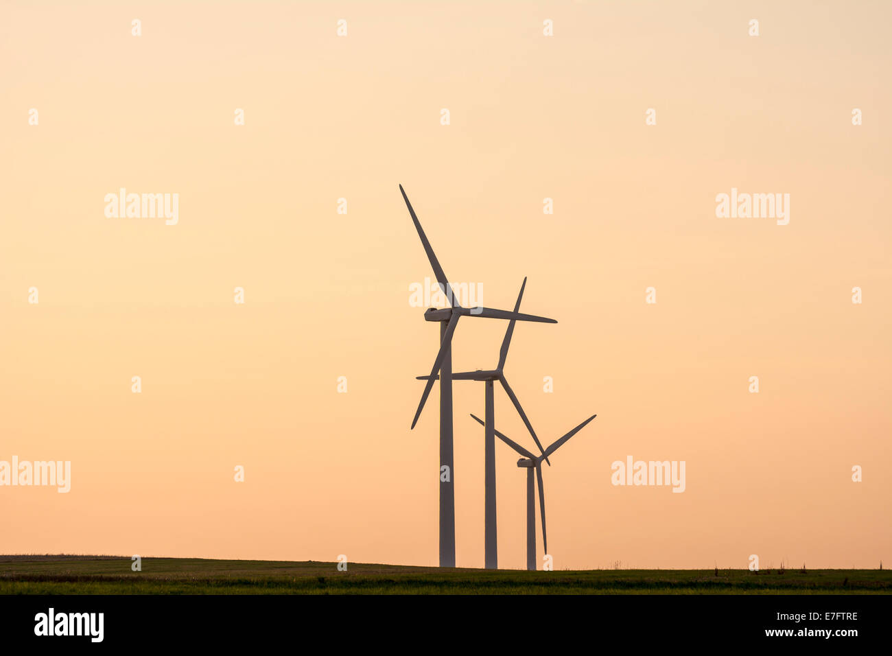 L'energia alternativa con potere di vento - il mulino a vento di tre sagome in il tramonto. Foto Stock