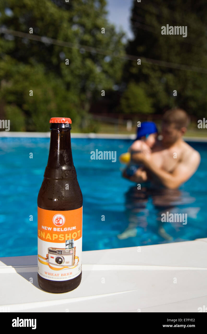 Bottiglia di nuovo Belgio Snapshot Birra di frumento accanto alla piscina Foto Stock