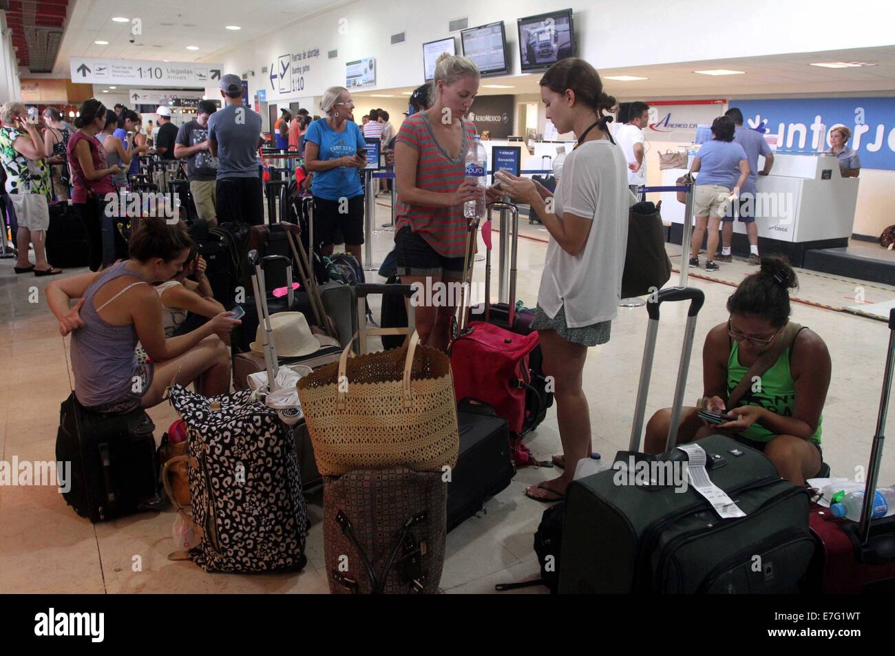 Mazatlan, Messico. 16 Sett 2014. I turisti evacuati da Los Cabos dopo l uragano Odile colpite la zona, attendere accanto ai loro bagagli all'aeroporto di Mazatlan, nello stato di Sinaloa, Messico, Sett. 16, 2014. Il governo messicano ha iniziato a filamento airlifting turisti fuori dall uragano-devastato area resort di Los Cabos martedì. Credito: Juan Perez/Xinhua/Alamy Live News Foto Stock