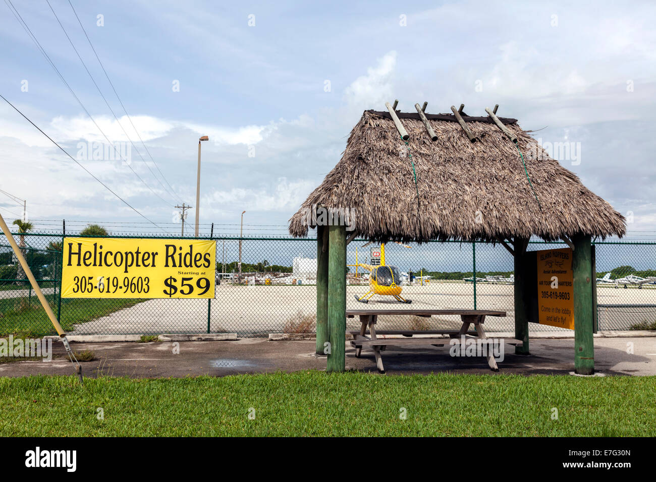 Elicottero giallo, piccolo tiki hut e pic-nic table serve come piccola area di attesa per il giro in elicottero servizio in Florida Keys, Foto Stock