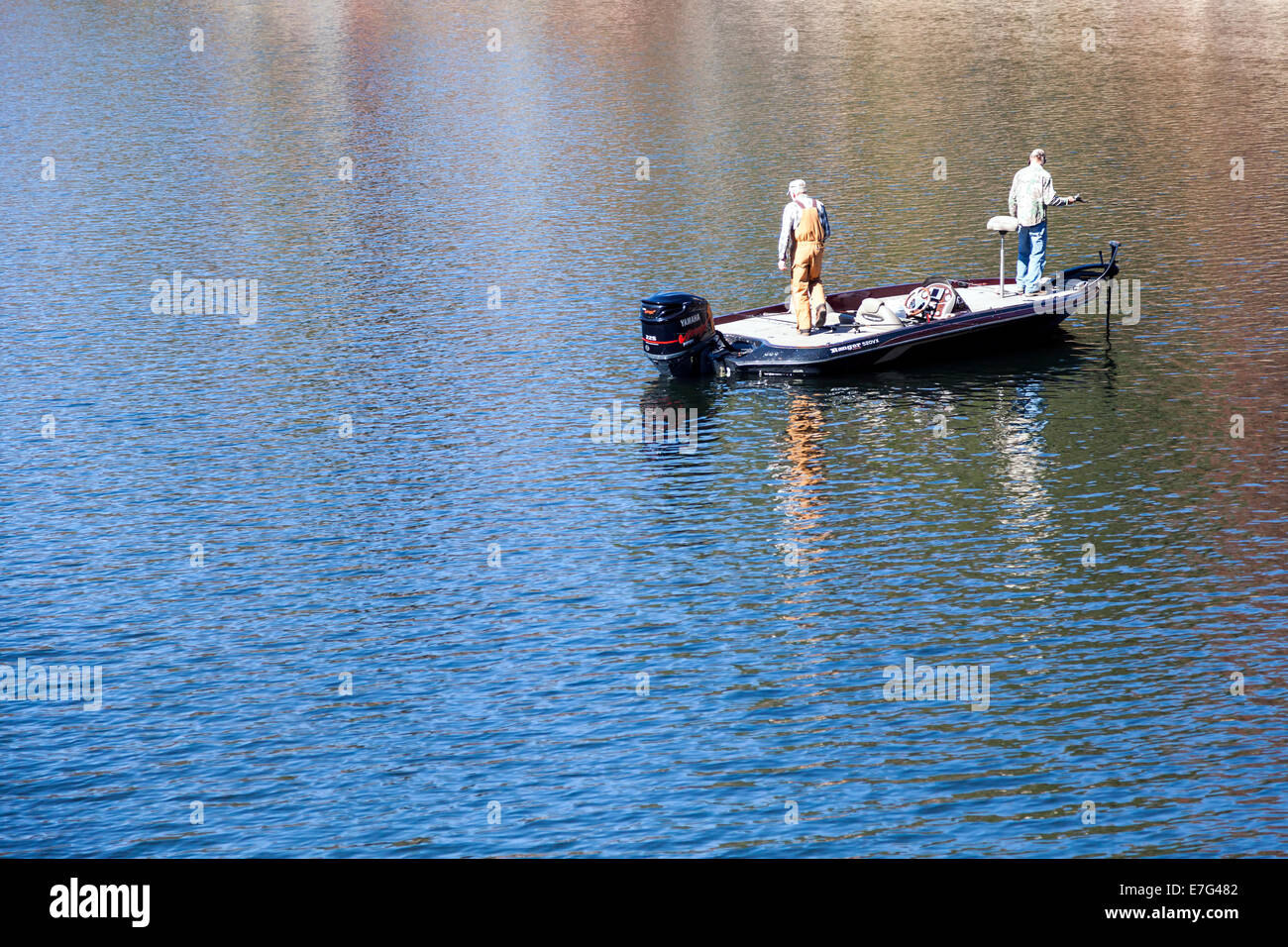 Due pescatori in piedi su una barca da pesca sul lago di Glenville vicino cassieri, Carolina del Nord in un pomeriggio autunnale. Foto Stock