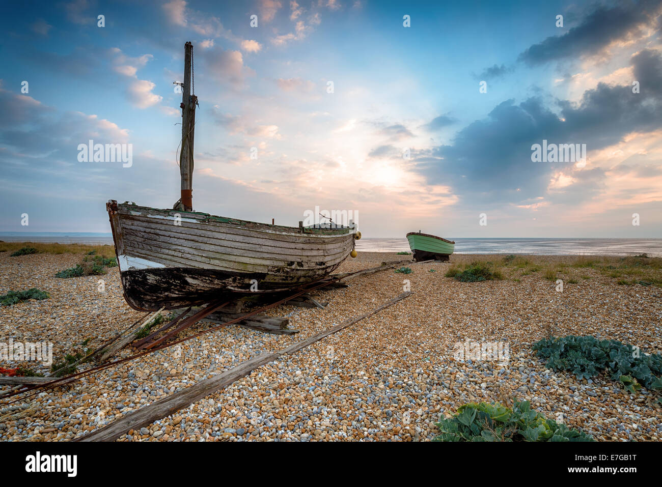 Barche da pesca su una spiaggia di ciottoli a Lydd-su-Mare in Romney Marsh, Kent Foto Stock