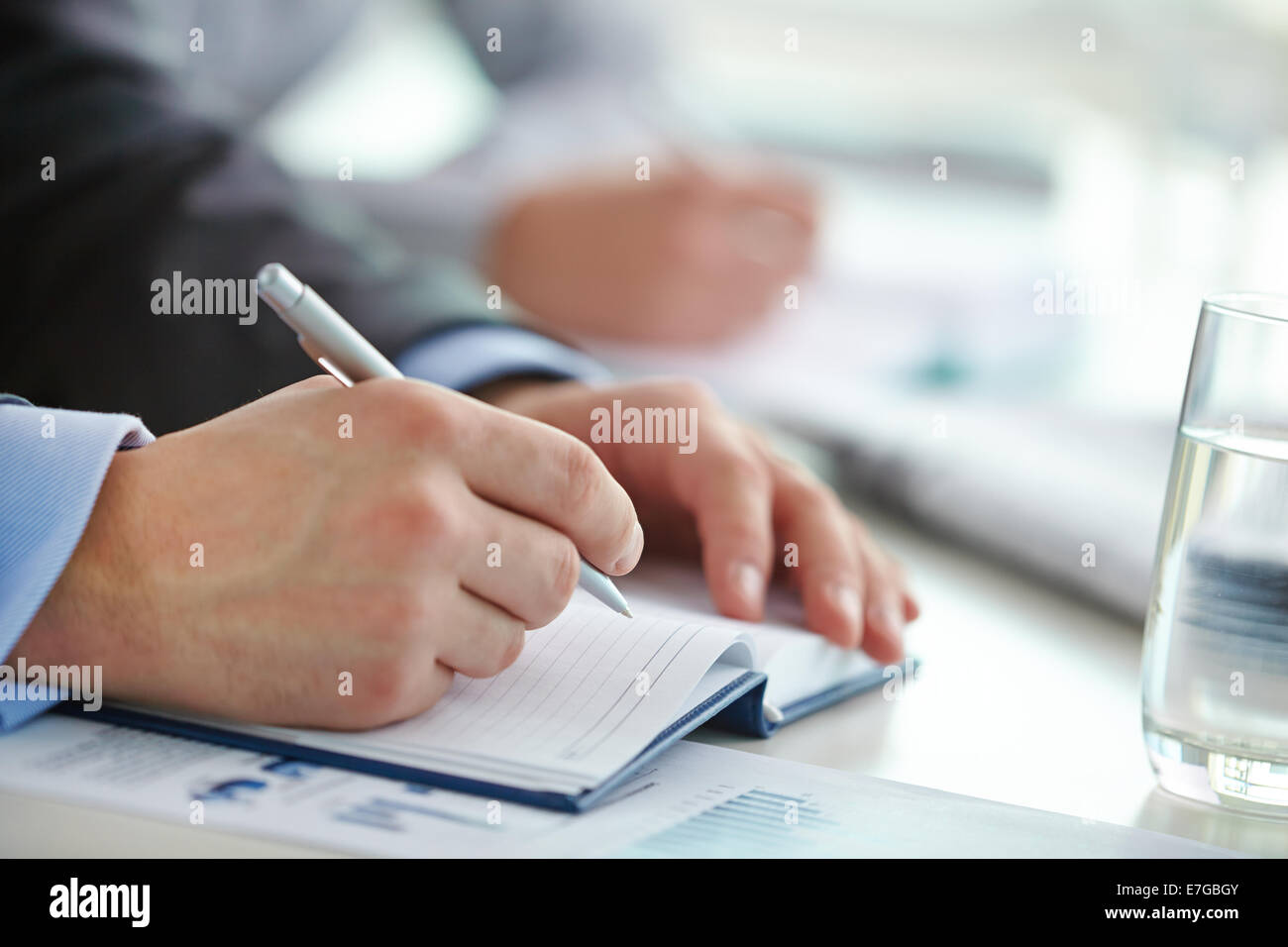 Mano maschio con penna rendendo note in notebook a lezione Foto Stock