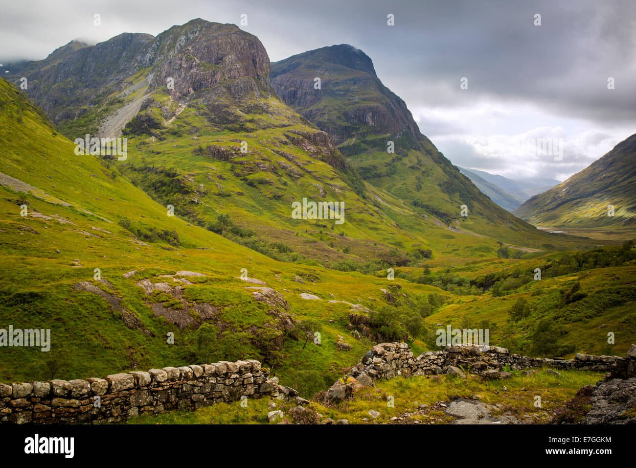 Muro di pietra e vista sulla valle sotto le montagne di Glencoe, Lochaber, altopiani, Scozia Foto Stock
