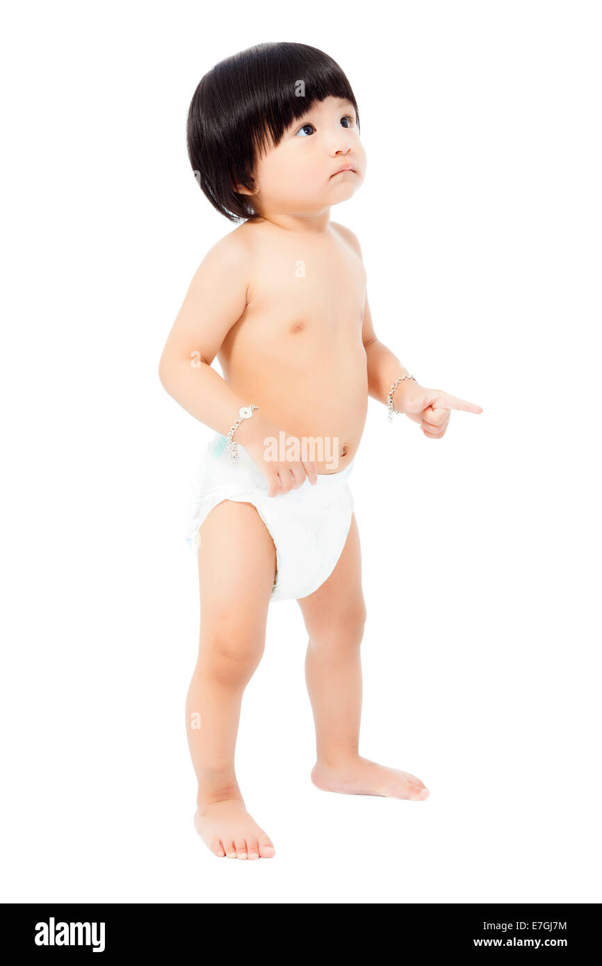 Carino Baby girl in un pannolino in piedi e guarda in alto isolato su sfondo bianco Foto Stock