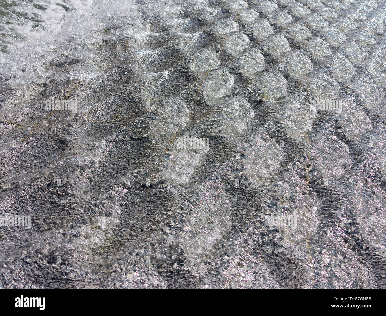 Close up dettaglio di acqua che scorre sulla trama della superficie in granito della Diana, principessa di Galles fontana commemorativa London Inghilterra England Foto Stock