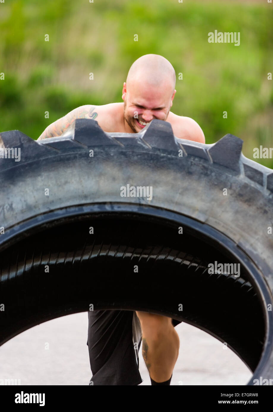 Atleta determinato facendo pneumatico-flip esercizio Foto Stock