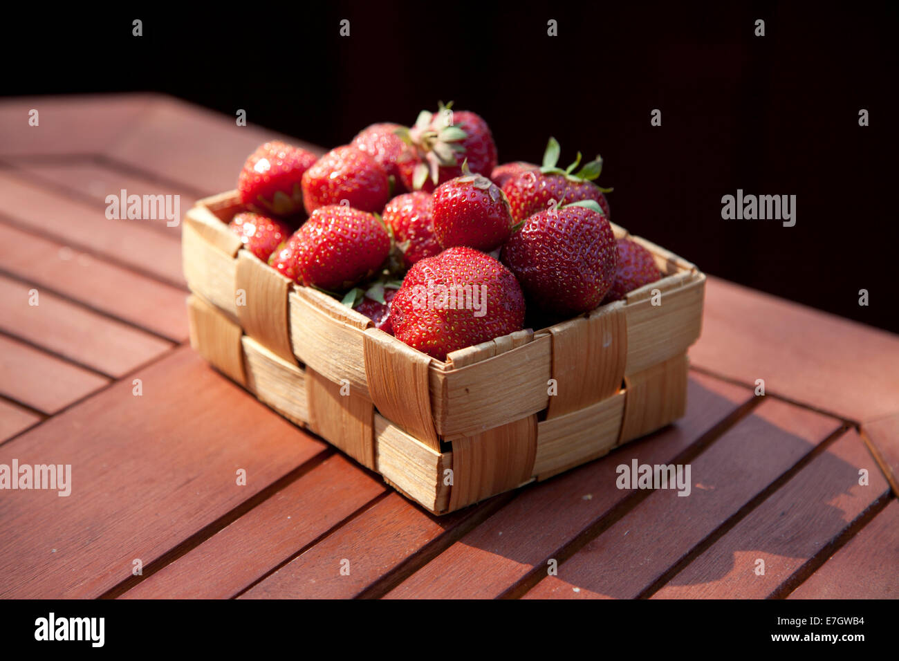 Fragole fresche nel cestello sul tavolo di legno sfondo Foto Stock