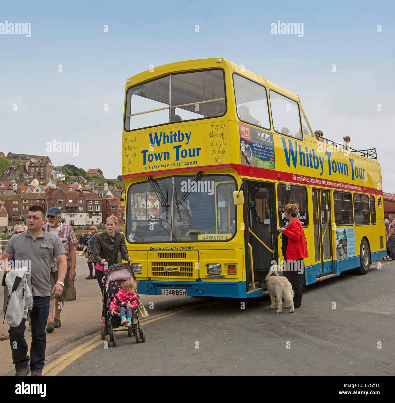 Giallo a sommità aperta double decker bus tour, popolare attrazione turistica in inglese città costiera di Whitby,con i passeggeri con il cane in attesa di bordo Foto Stock