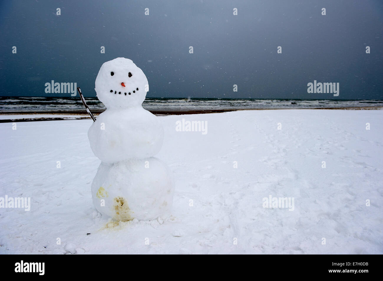 Pupazzo di neve sulla spiaggia innevata Foto Stock