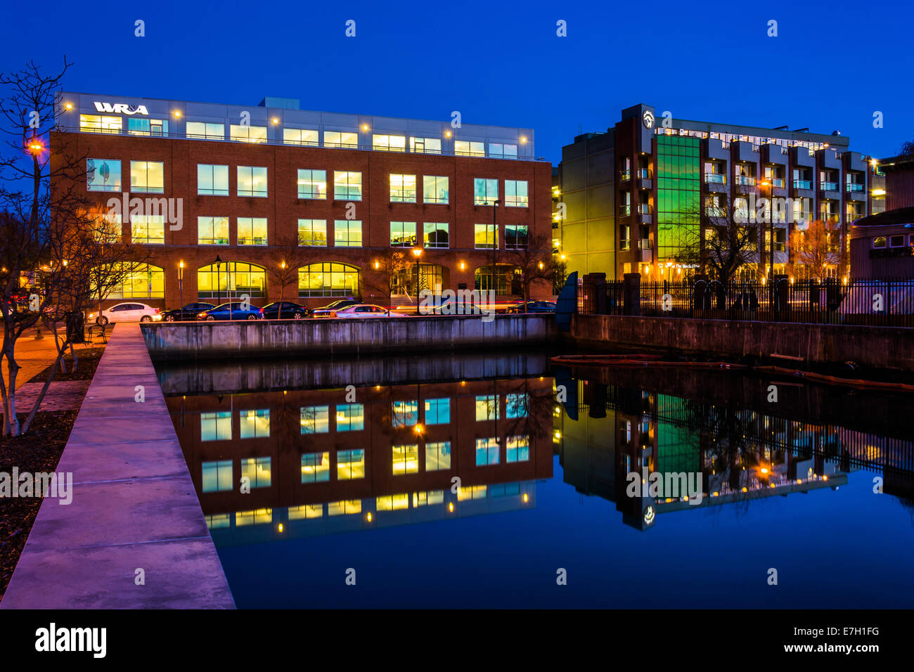 Edificio che riflette nell'acqua di notte a Baltimora, Maryland. Foto Stock