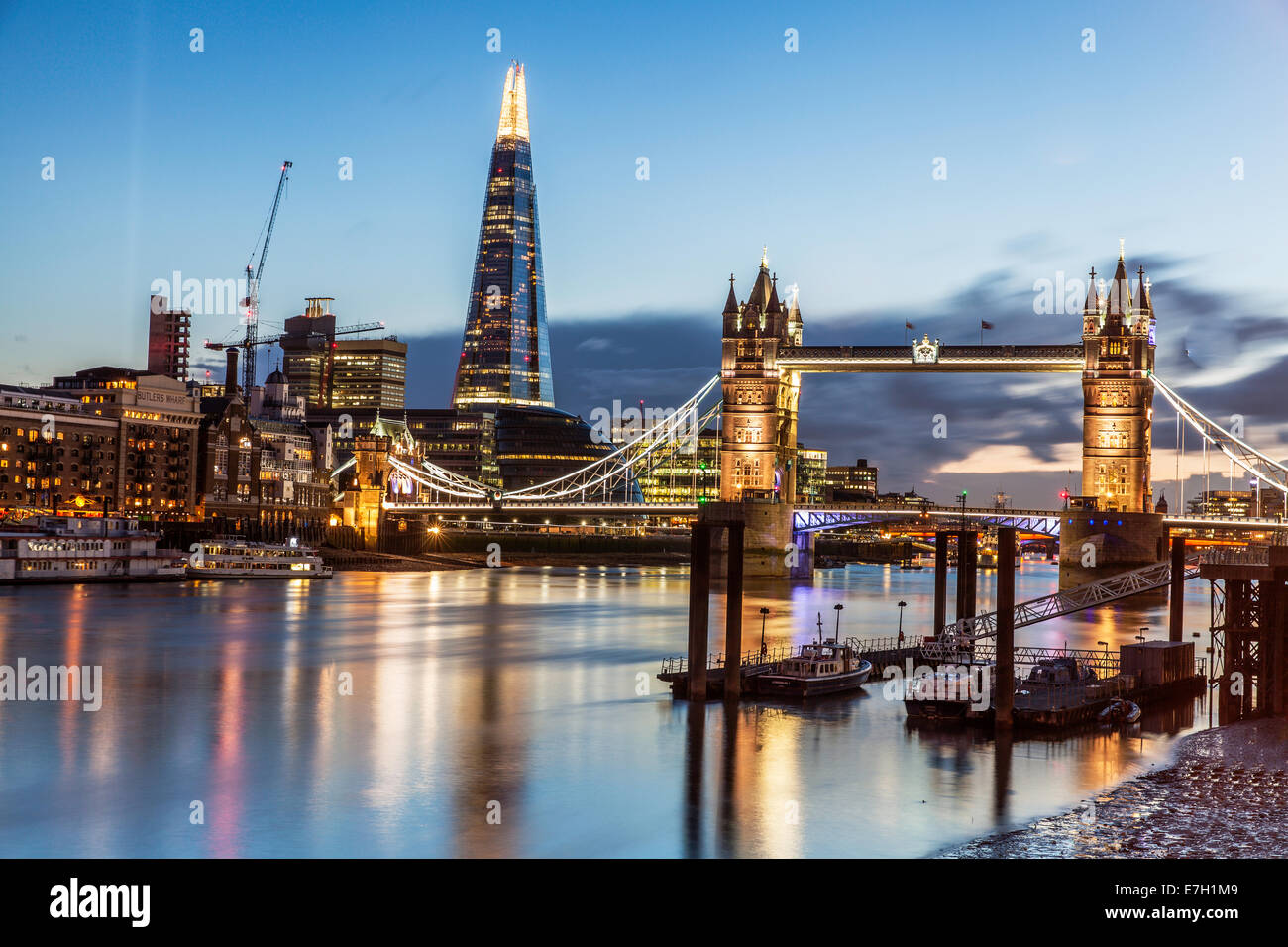 Vista notturna di St Katherine's Pier, Tower Bridge a Shard a Londra con colori luminosi e drammatico cielo nuvoloso Foto Stock