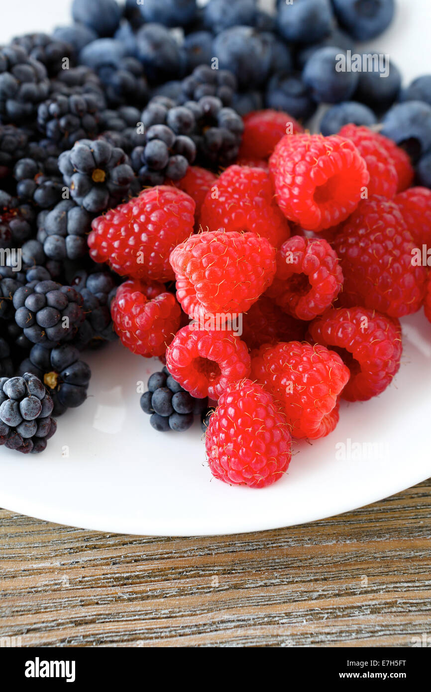 Un assortimento di Berry su una piastra bianca, cibo closeup Foto Stock