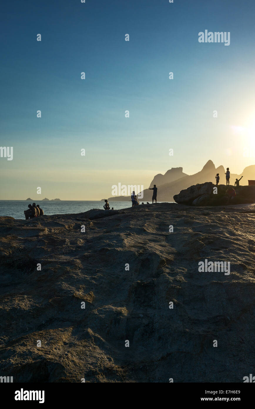 Il Brasile, Rio de Janeiro, la gente sulla Pedra do Arpoador promontorio al tramonto Foto Stock