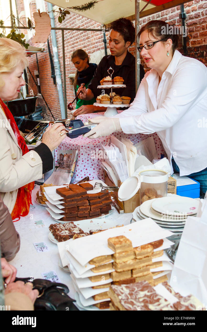 DORDRECHT, Paesi Bassi - 29 settembre 2013: Costomer pagando con la carta di credito per i prodotti sulla bancarella vendendo torte di tè, cioccolato Foto Stock