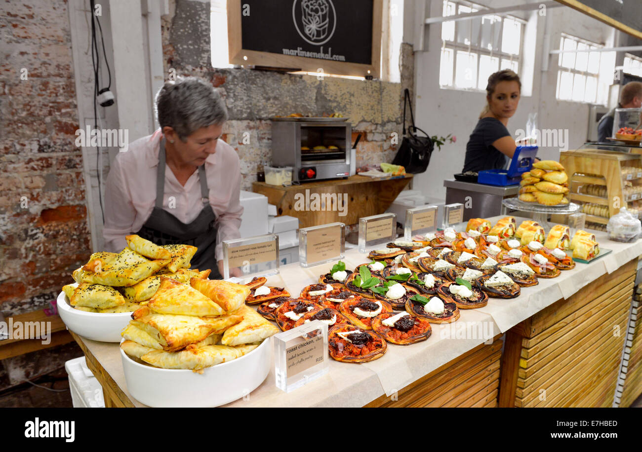 La pasticceria e la Pizza in vendita presso la old biscuit mill street market alimentare a Città del Capo in Sud Africa Foto Stock