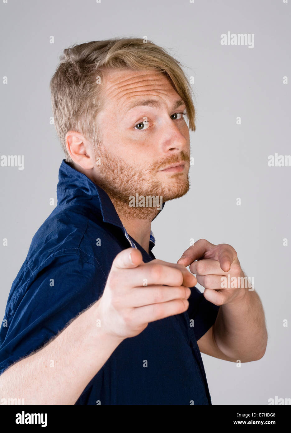 Giovane uomo che fa un gesto di puntamento con le sue dita Foto Stock