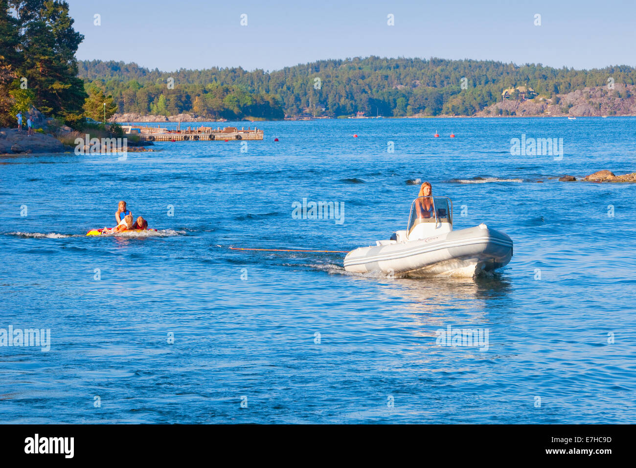 Stoccolma, Svezia - Madre in motoscafo tirando i bambini in rubberboat. Foto Stock