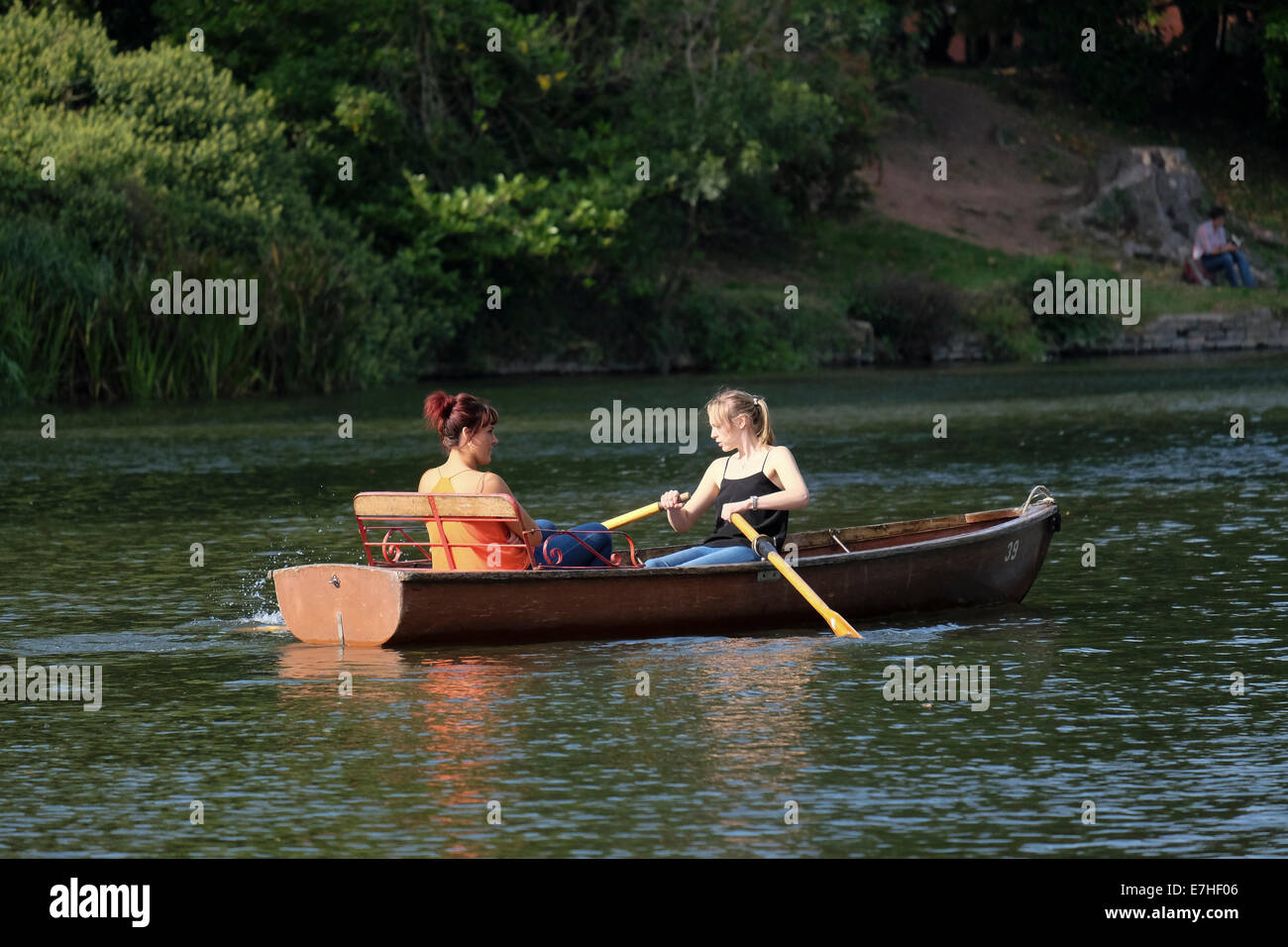 Coppia di giovani donne a noleggio una barca a remi sul fiume Avon a Stratford Foto Stock