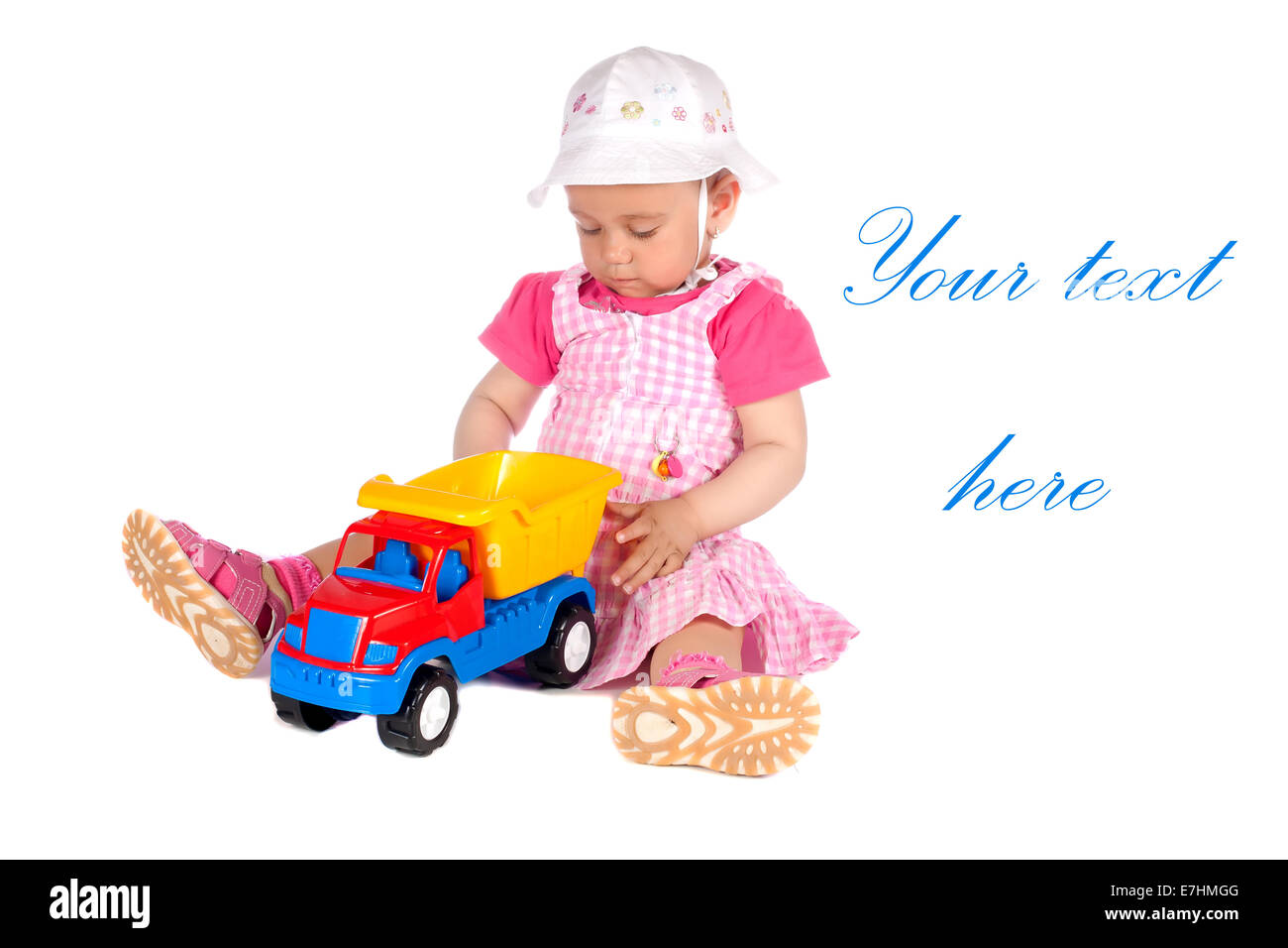 Baby girl giocando con il giocattolo carrello in studio, isolato su sfondo bianco Foto Stock