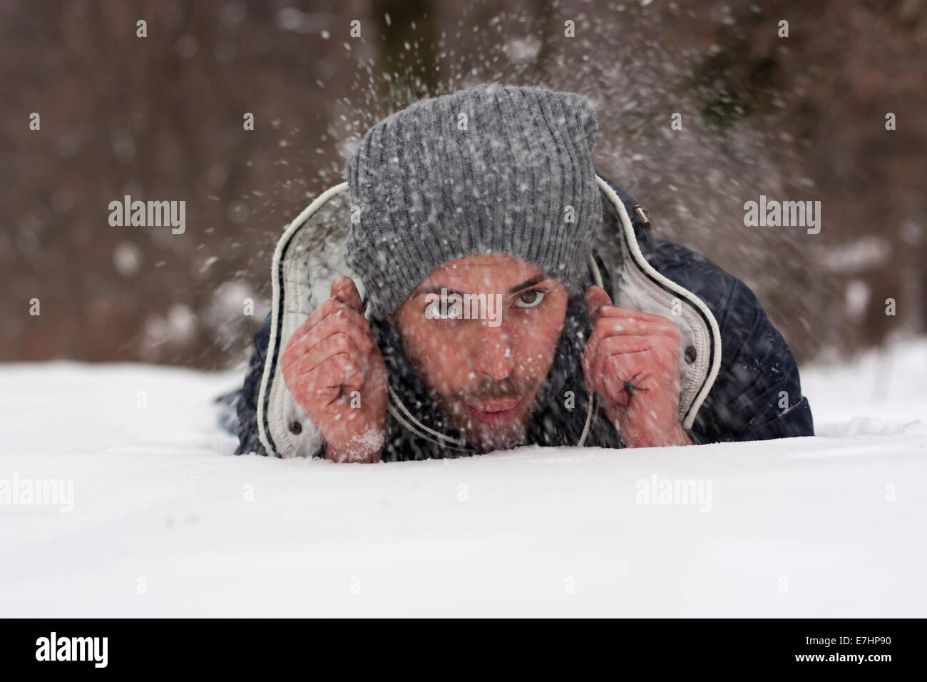 Giovane uomo disteso lavori di soffiaggio della neve Foto Stock