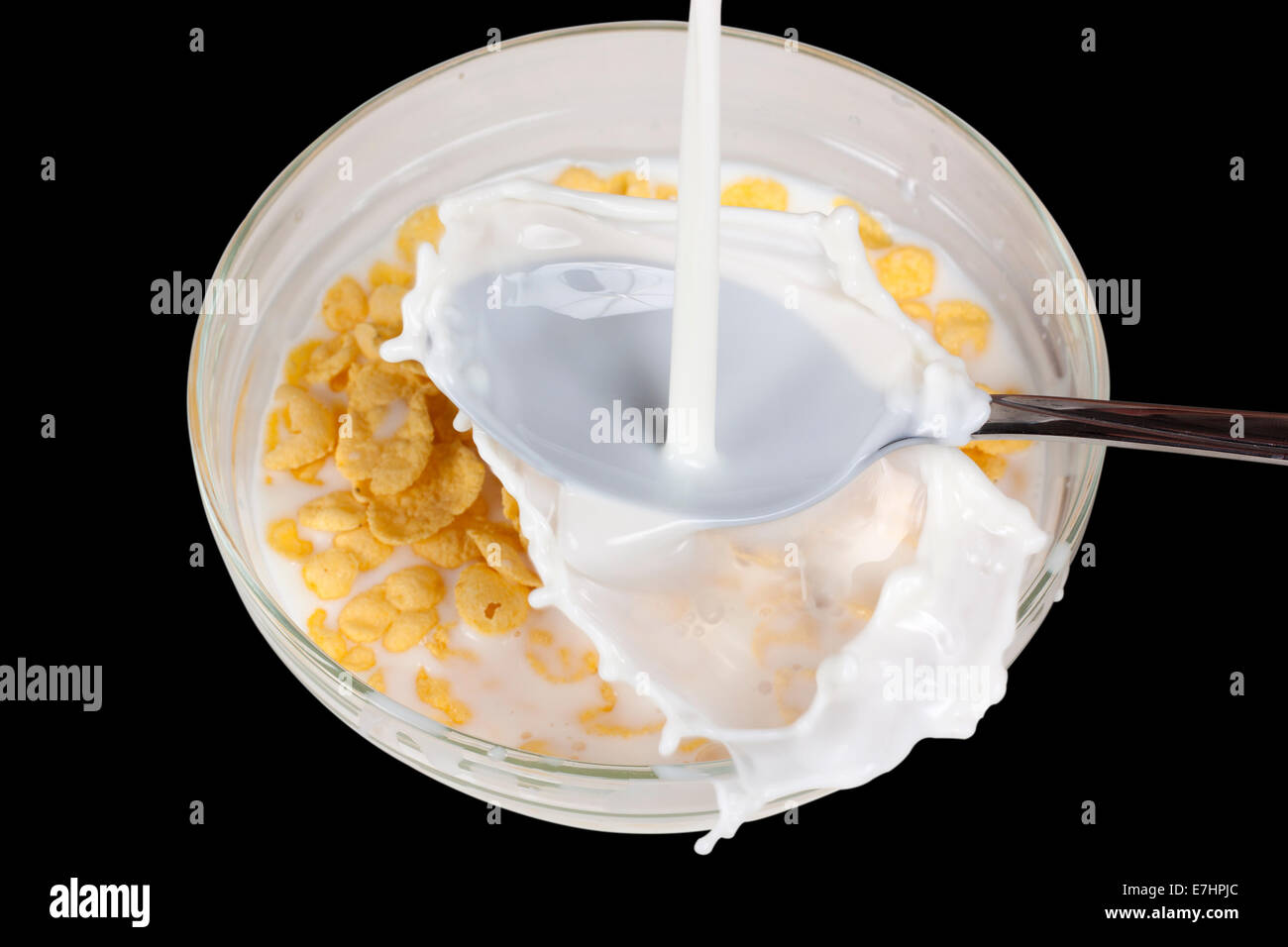 Cereali in ciotola e splash latte isolate su sfondo nero con tracciato di ritaglio Foto Stock