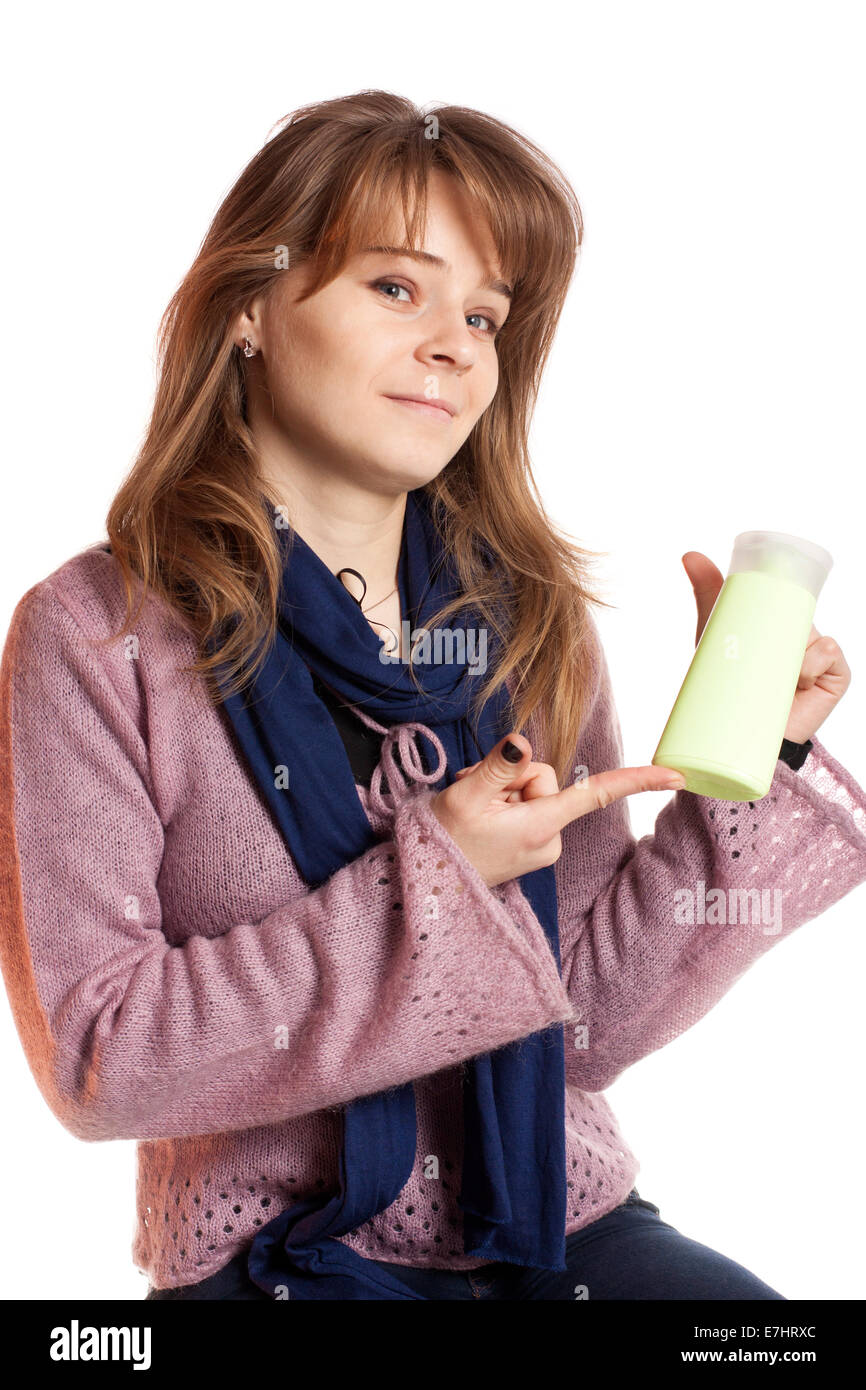 Giovane donna tenendo in mano la bottiglia vuota shampoo isolate su sfondo bianco Foto Stock