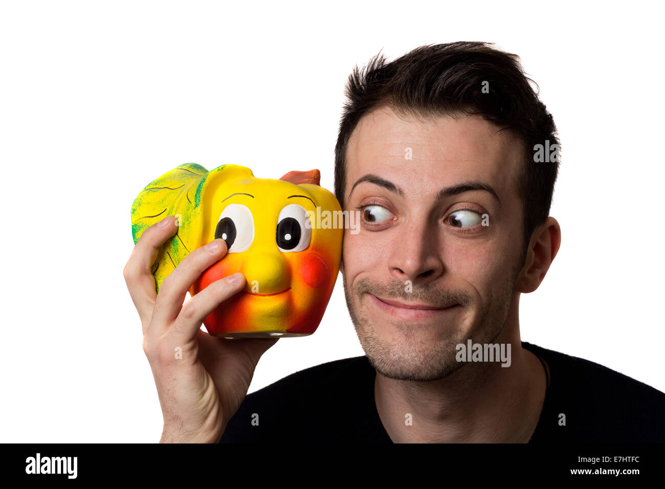 Funny Man guardando una ceramica apple isolate su sfondo bianco Foto Stock