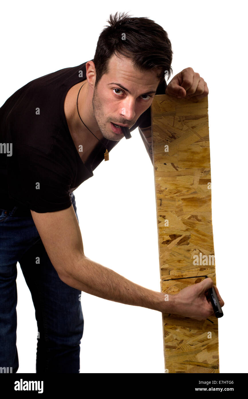 Giovane uomo marcatura asse di legno isolato su sfondo bianco Foto Stock