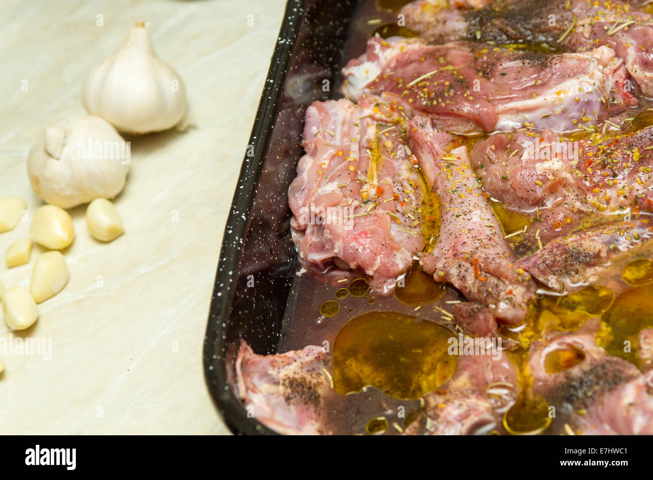 Primo piano di un vassoio di crudo agnello di ricambio prima di grigliare e un po' d'aglio sul tavolo Foto Stock