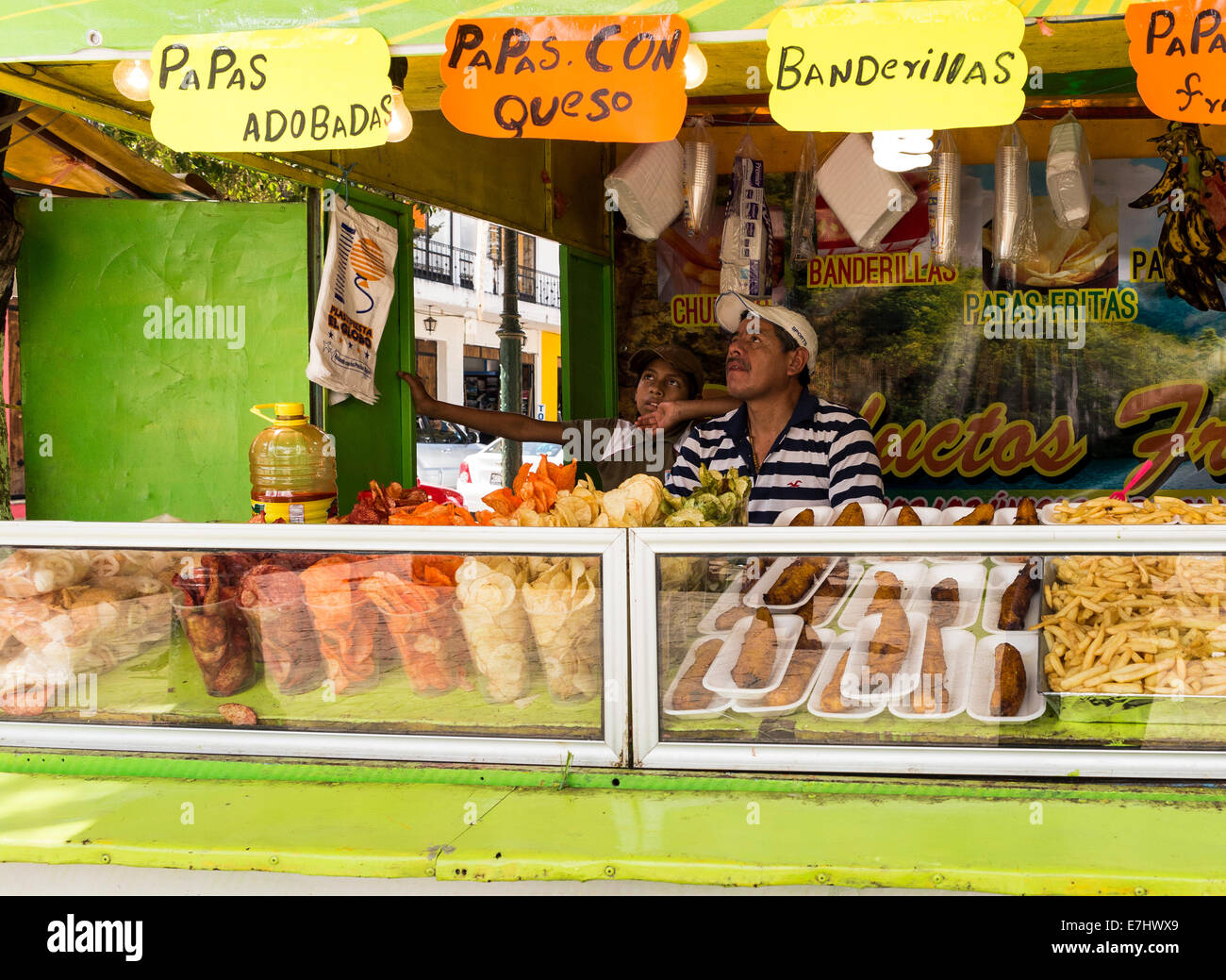 Uomo e ragazzo a guardare la tv in un mercato in stallo a San Cristobal de Las Casas, Chiapas, Messico Foto Stock