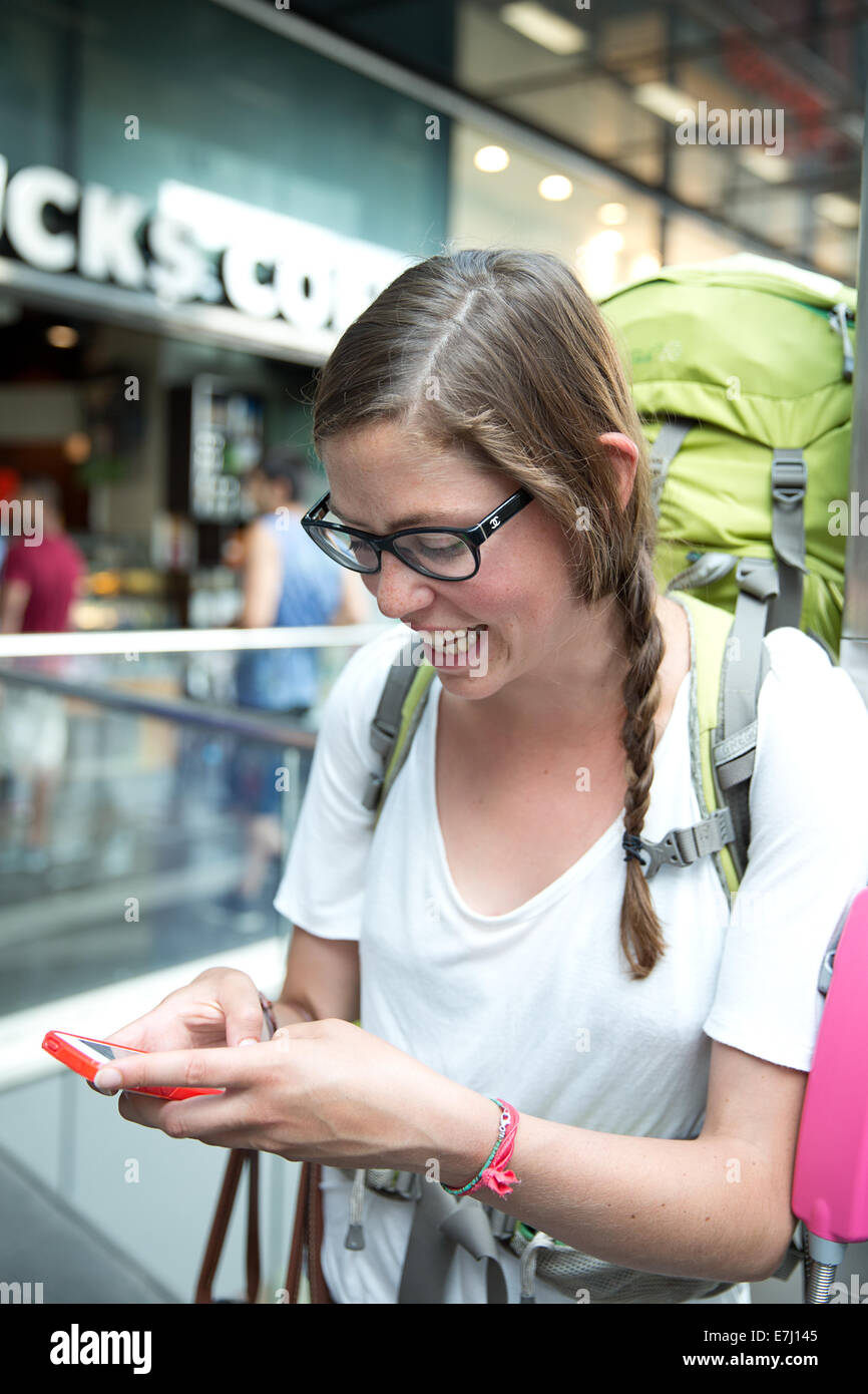 Un viaggiatore utilizzando un telefono intelligente. Foto Stock