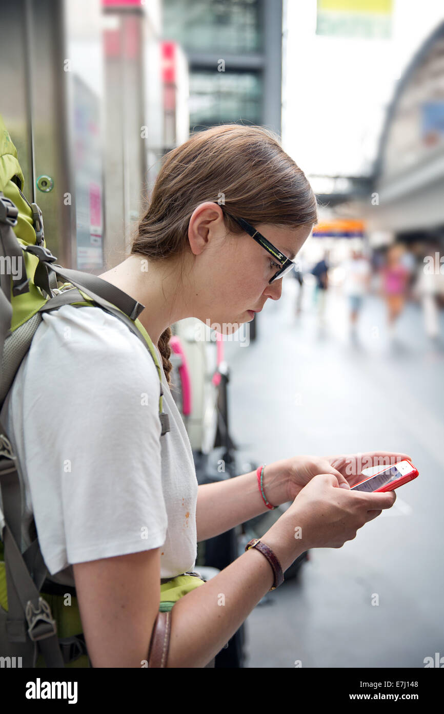 Un viaggiatore utilizzando un telefono intelligente. Foto Stock