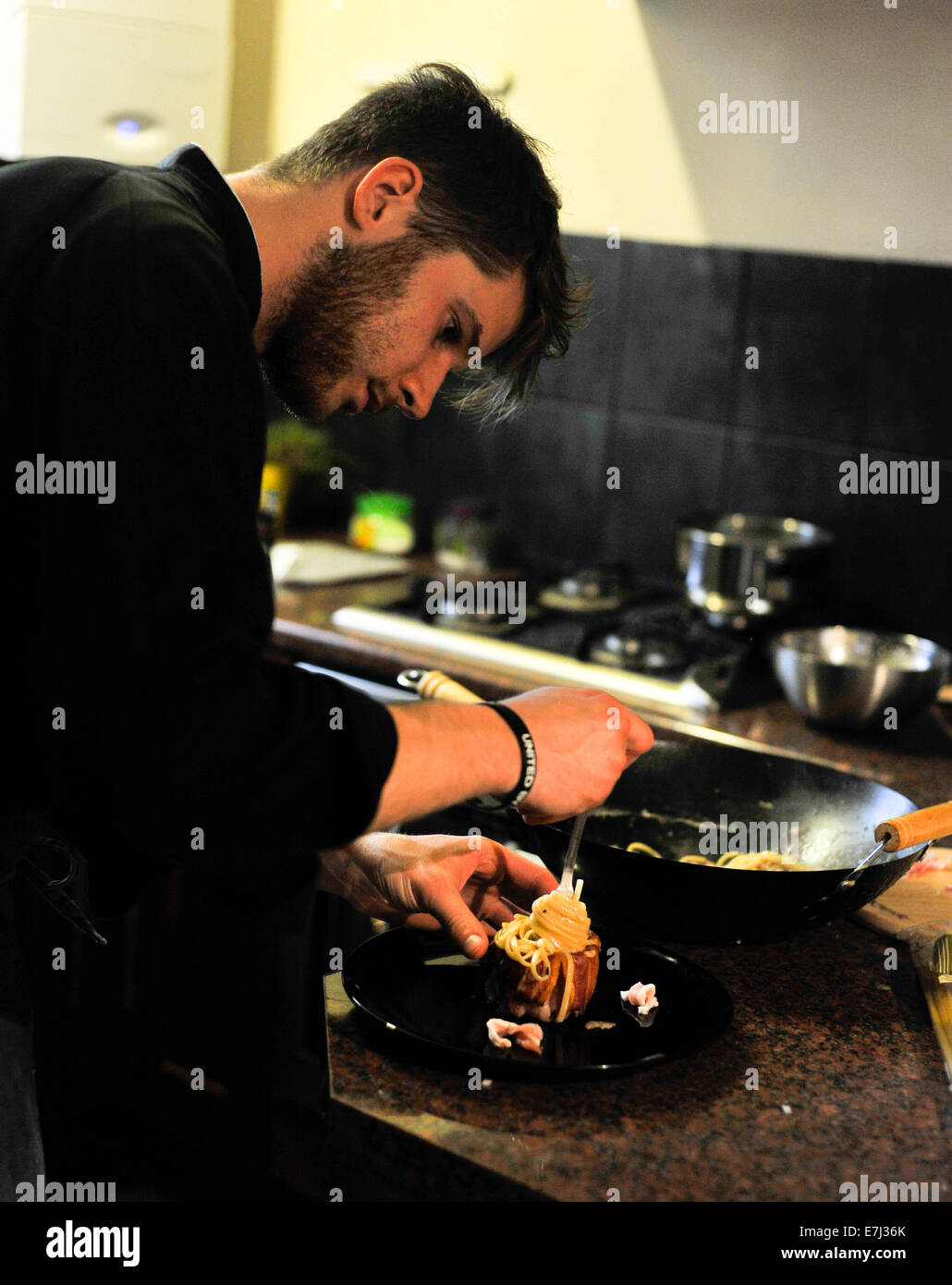 Il giovane chef cucinare una carbonara in una cucina Foto Stock