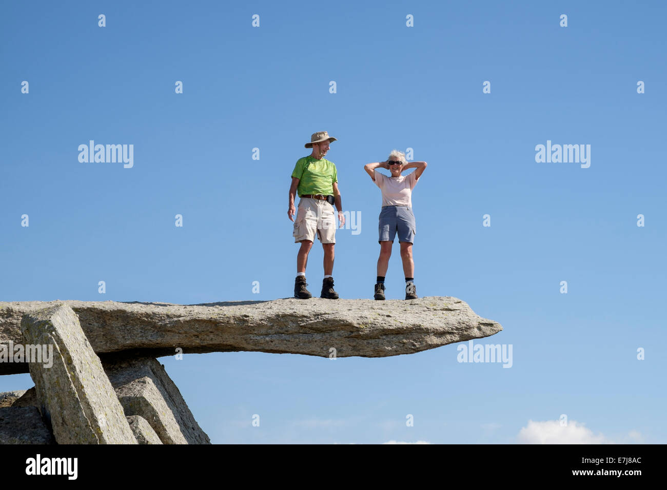 Due escursionisti senior in piedi sulla roccia a sbalzo sul FACH Glyder nel Parco Nazionale di Snowdonia, Wales, Regno Unito, Gran Bretagna Foto Stock