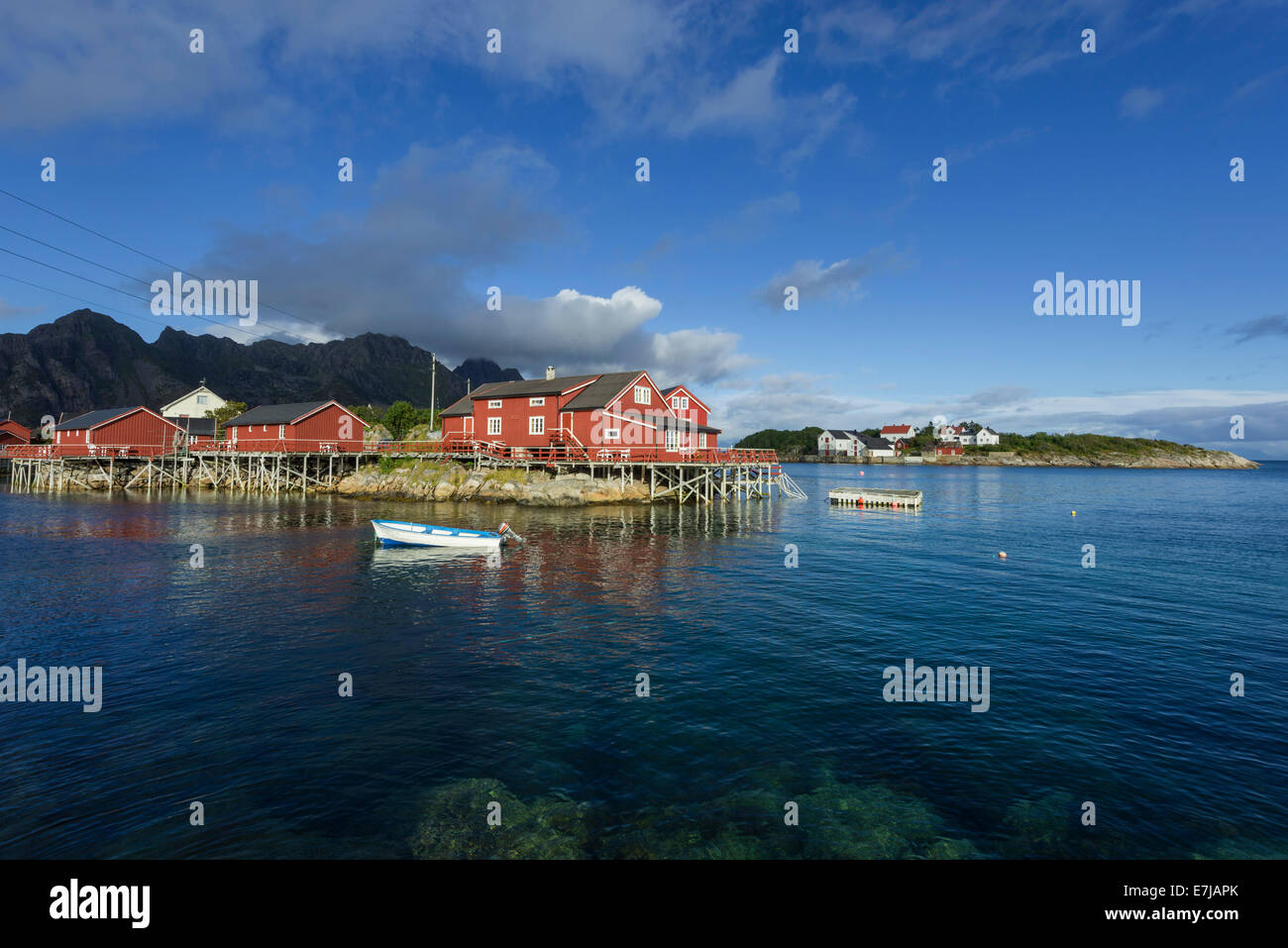 Rorbuer di pescatori di cabine con una piccola imbarcazione a motore, Henningsvaer, Lofoten, Nordland, Norvegia Foto Stock