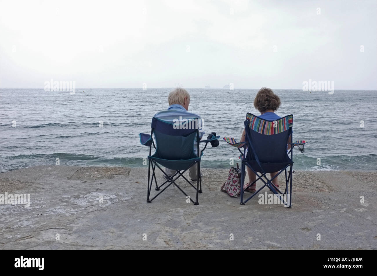 Un paio di sedersi in riva al mare in Falmouth, Cornwall Foto Stock