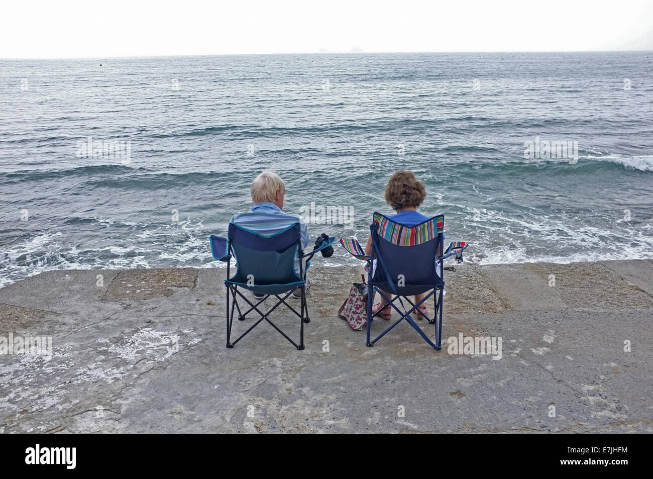 Un paio di sedersi in riva al mare in Falmouth, Cornwall Foto Stock