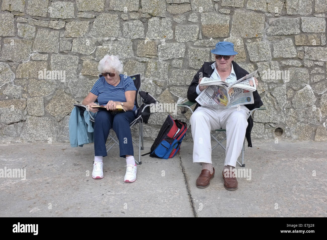 Una coppia in pensione sedersi da un mare di parete in Falmouth, Cornwall, Regno Unito Foto Stock