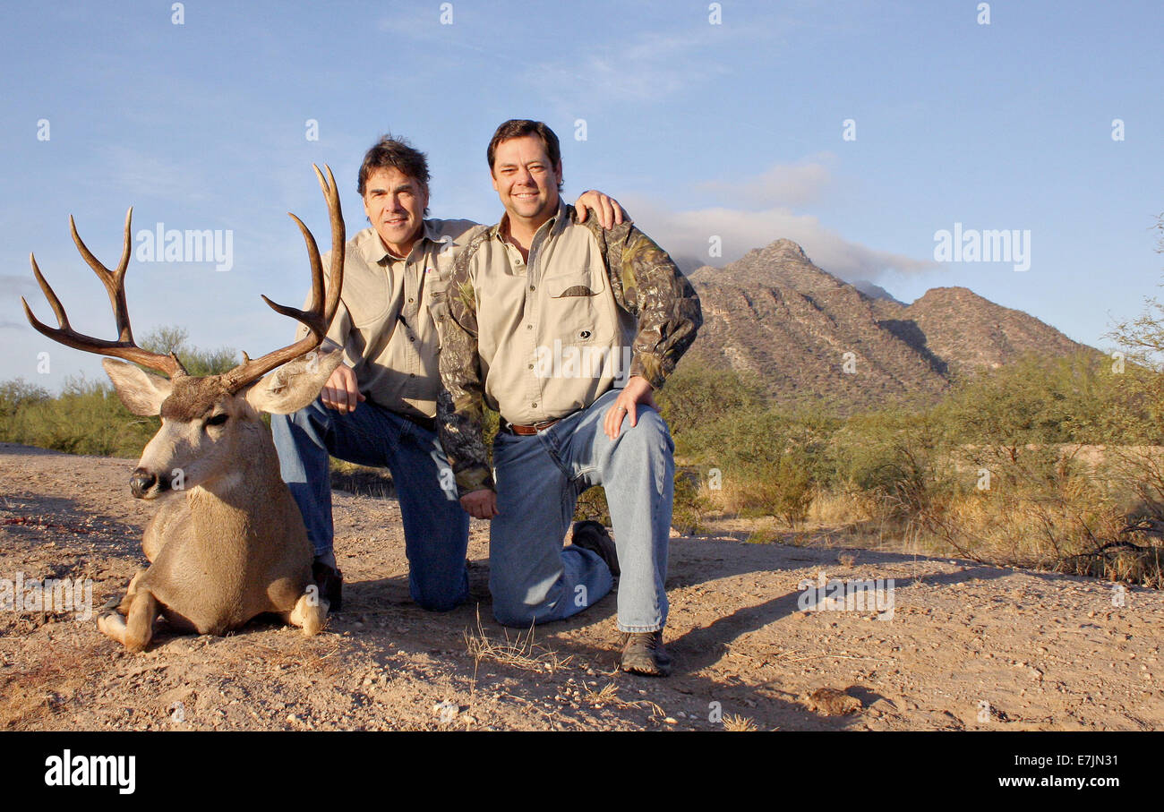 Texas Governor Rick Perry pone con un mulo cervo trofeo prese sulla sua famiglia terreno di caccia a nord di pascolo di Camp che utilizzano per essere noto come ranch Niggerhead 16 dicembre 2008 vicino Paint Creek, Texas. Foto Stock